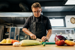 low-angle-male-chef-chopping-vegetables-kitchen 1